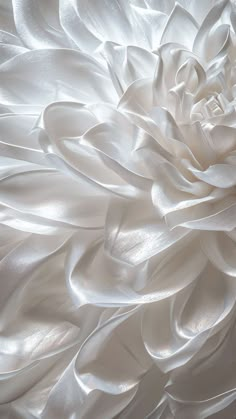 a white flower is shown in this close up photo, it appears to be made out of silk