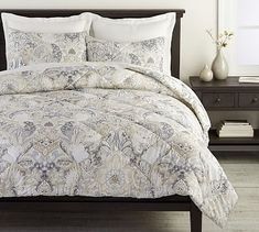 a bed covered in a white and blue comforter