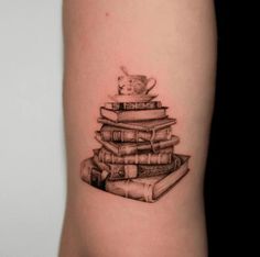 a stack of books with a tea cup on top tattoo by the talented artist in black and white