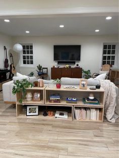 a living room filled with furniture and a flat screen tv mounted to the side of a wall