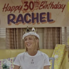 a woman wearing a crown sitting in front of a birthday sign