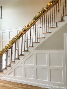 the stairs are decorated with christmas garland and lights for an elegant holiday look to your home