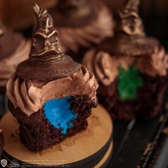 some cupcakes with chocolate frosting and witches hats on top