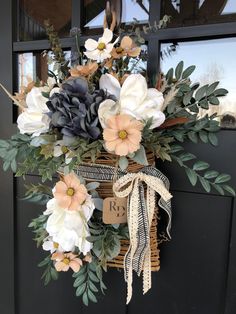 a basket with flowers hanging on the front door