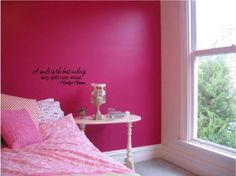 a bedroom decorated in pink and white with a flower wall decal on the wall