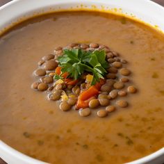 a white bowl filled with lots of food on top of a table