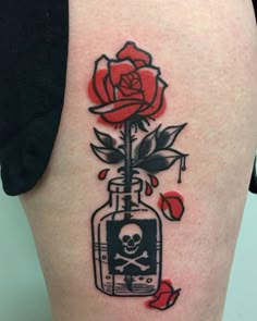 a skull and rose tattoo on the back of a woman's thigh, which is decorated with red roses