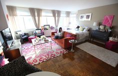 a woman sitting on top of a couch in a living room next to a tv