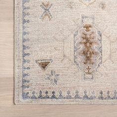 an old rug on a wooden floor with white and blue colors in the middle,