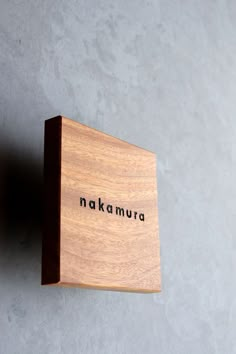 a wooden block with the word nakamura written in black on it's side