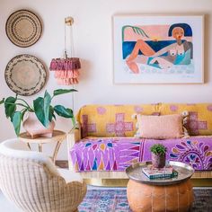 a living room filled with lots of furniture and art on the wall above it's couch