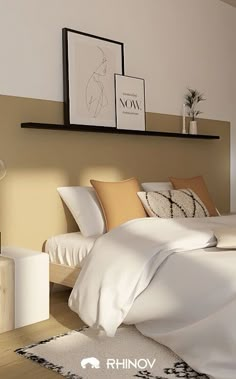 a white bed sitting in a bedroom next to a wall mounted shelf with pictures on it