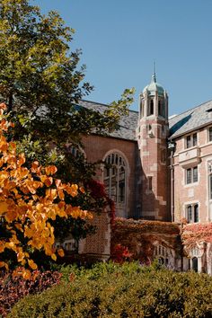 an old brick building with a clock tower in the middle of it's front yard