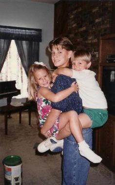 three children are hugging each other in the living room