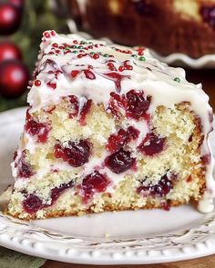 a piece of cake with white frosting and cranberry topping on a plate