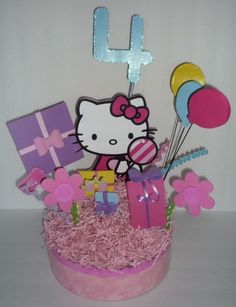 a hello kitty birthday cake with balloons and presents