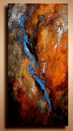 an abstract painting with brown, blue and orange colors on it's surface is hanging on a wall