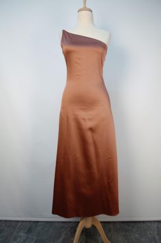 a dress on a mannequin stand in front of a white wall