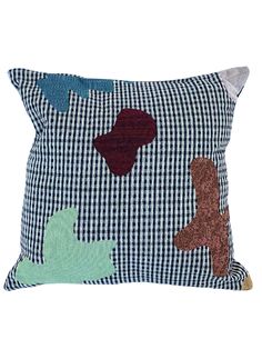 a blue and white pillow with different colored patches on the front, along with a brown teddy bear