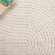 a close up view of a white rug with blue and green designs on the edges