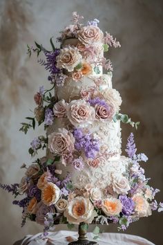 a wedding cake decorated with flowers and greenery