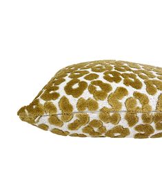 a leopard print pillow with white and gold spots on the front, sitting against a white background