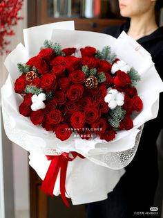 a woman holding a bouquet of red roses