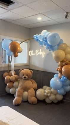 there is a teddy bear and balloons in the room