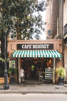 a cafe with green and white awnings on the side of it's building