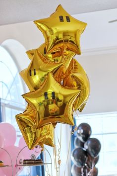 gold star shaped balloons are hanging from the ceiling