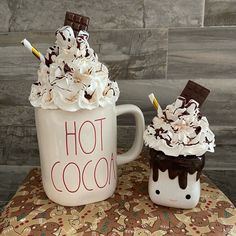 two coffee mugs decorated with whipped cream and chocolate