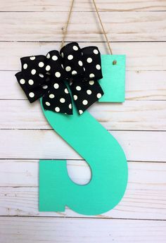 the letter s is decorated with black and white polka dots on green wood planks