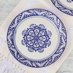 two blue and white plates sitting on top of a table