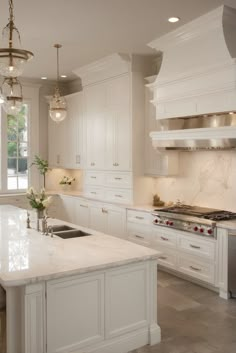 a large kitchen with white cabinets and marble counter tops, along with an island in the middle