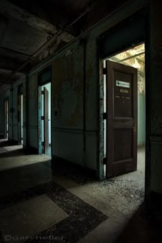 an empty room with peeling paint on the walls and doors open to let in light