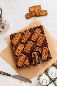 there are cookies on top of the brownies next to some candles and utensils