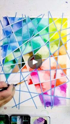 someone is painting on the wall with colorful squares and lines in watercolor pencils