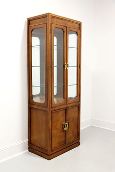 a wooden display case with glass doors on the top and bottom, against a white wall