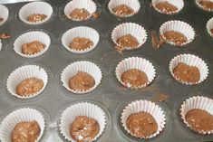 cupcakes with chocolate frosting in paper cups on a baking tray ready to go into the oven