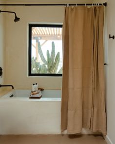 a bath tub sitting next to a window in a bathroom