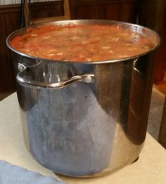 a large metal pot filled with soup on top of a table