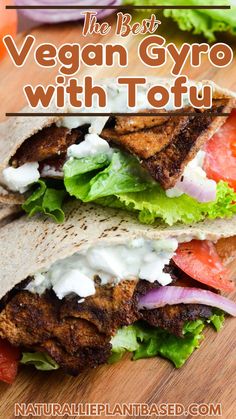 the best vegan gyro with tofu on a wooden cutting board next to lettuce and tomatoes