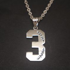 the number five is made out of metal and has a baseball stitch on it's side