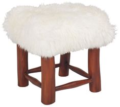 a white sheepskin stool with wooden legs