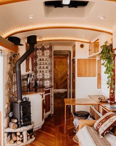 a living room filled with furniture and a fire place in the middle of a kitchen