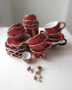 a pile of red and white dishes sitting on top of a table