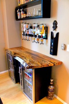 a wooden counter top sitting in the middle of a room next to shelves filled with bottles and glasses