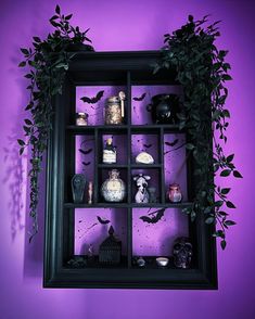 a black shelf filled with lots of halloween decorations on top of a purple wall next to a potted plant