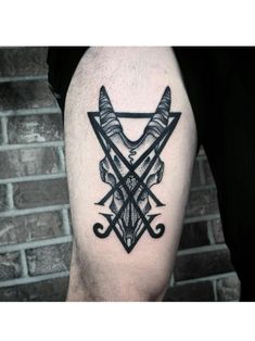 a black and white tattoo on the leg of a man with two knives in it