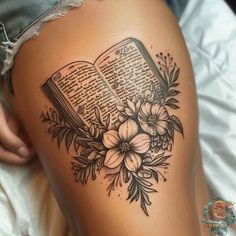 a woman's thigh with an open book and flowers on it